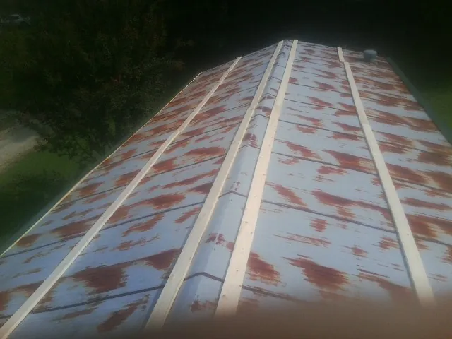 Rusted metal roof panels with new wood purlins before replacement — Storm Damage Roof Repair in Aneta by Roofing Brothers