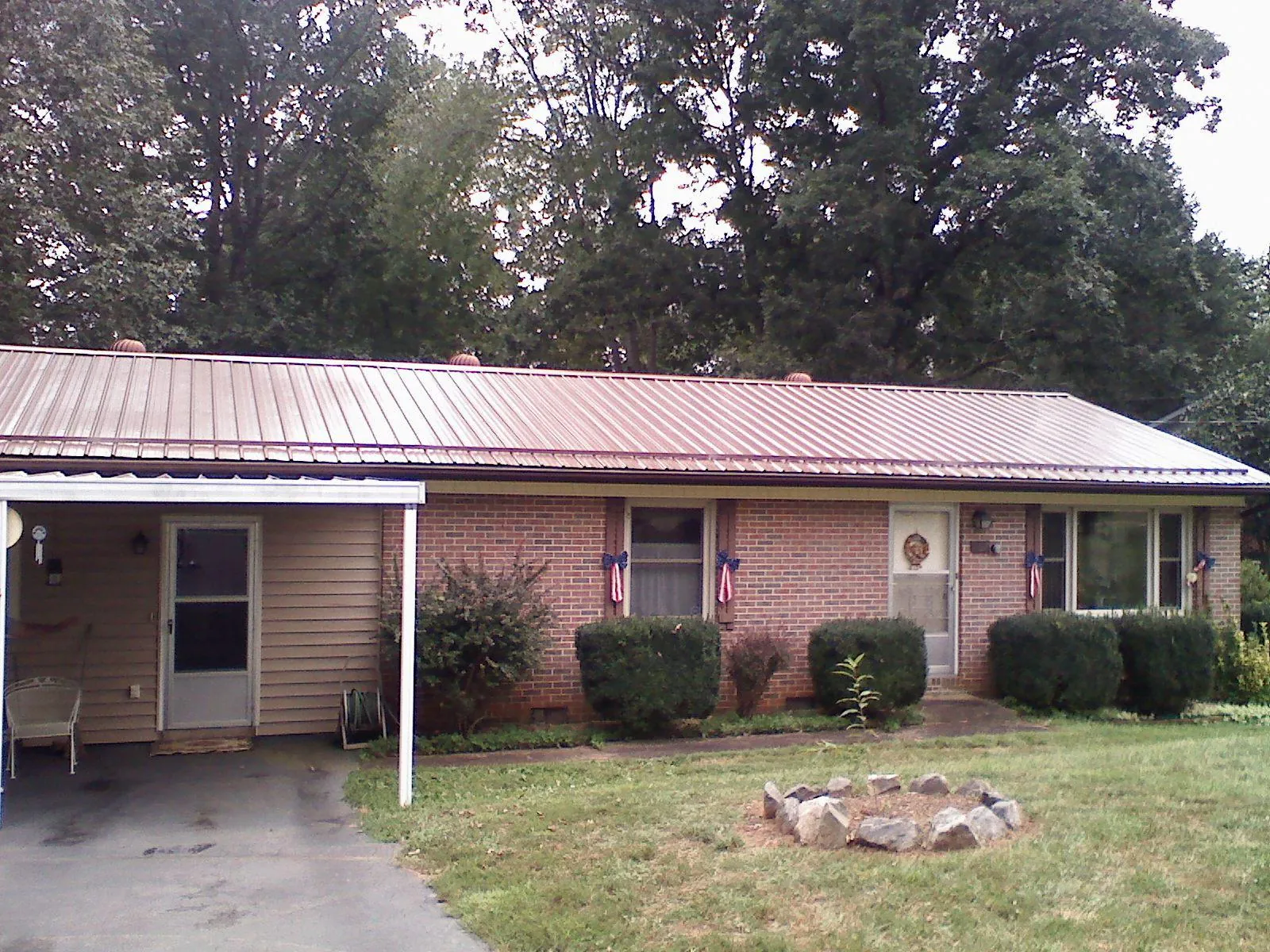 Bronze metal roof and carport on a brick ranch home — Roof Repair work by our crew in Aneta